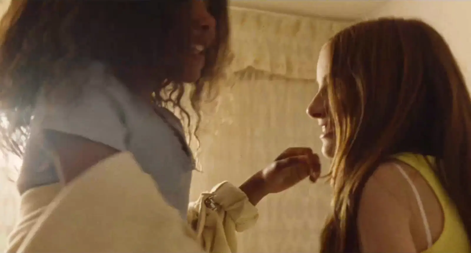Two girls laughing together in a warmly lit room